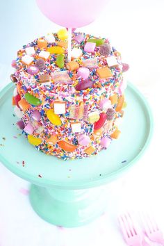 a birthday cake with sprinkles and a pink balloon