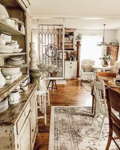 a dining room table with chairs and a rug on the floor in front of it