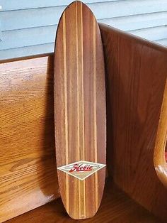 a wooden surfboard leaning up against a wall