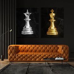 an orange leather couch in front of two gold and silver chess pieces