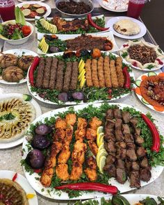 a table topped with lots of plates filled with food