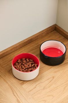 two bowls filled with red liquid next to each other on a wooden counter top,