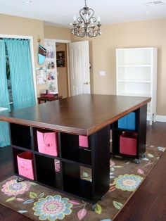 a room with a table and several bins on the floor in front of it