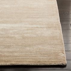 a beige rug on a wooden floor