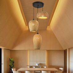 a dining room table and chairs with lights hanging from the ceiling above it in an open space