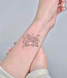 a woman's arm with a tattoo on it that has a small snake on the wrist