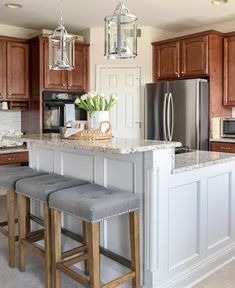 a kitchen with two stools and a center island