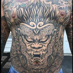 a man with tattoos on his back and chest