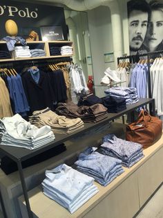 clothes are on display in the store for men's shirts and sweaters to be worn