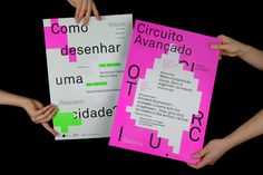 two people holding up posters with words on them in spanish and english, against a black background