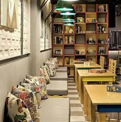 a restaurant with lots of tables and chairs in it's center area, along with shelves full of books