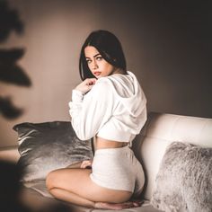 a woman sitting on top of a white couch