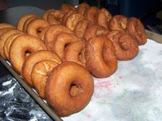 doughnuts are lined up on a tray ready to be baked in the oven