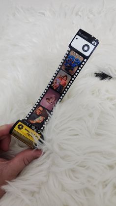 a hand holding a film strip with pictures on it and an animal's paw next to it