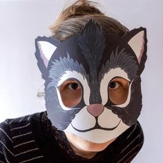 a woman wearing a mask with a cat's face painted on the front and side