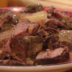 a close up of a plate of food with meat and gravy on it