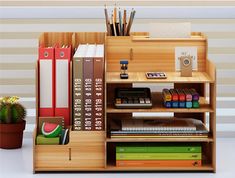 a book shelf with books, pens, and other office supplies on top of it