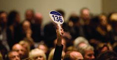 a person holding up a blue and white sign in front of a crowd