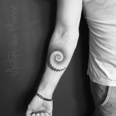 a black and white photo of a person's arm with a tattoo on it