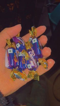 a person holding several candy bars in their hand