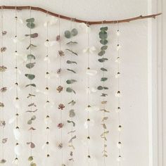 a white wall hanging with flowers and leaves on it's side, in front of a door