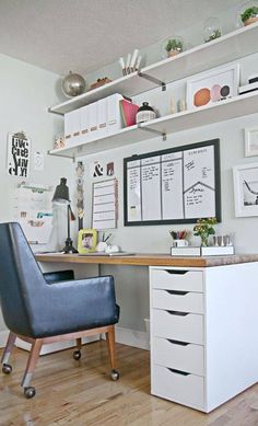 an office with white shelves and blue chair in front of the desk is full of papers