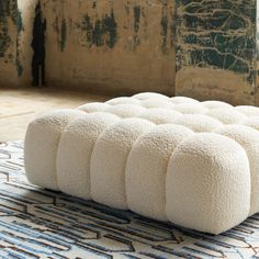 a white ottoman sitting on top of a rug