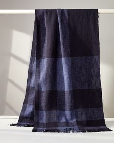 a black and blue checkered blanket sitting on top of a bed