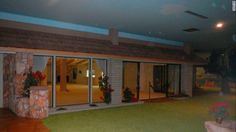 an empty room with sliding glass doors on the outside and green carpeted flooring