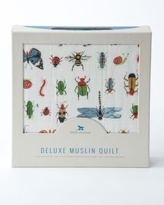 the box is open to show an assortment of bugs and insects on white fabric with blue trim