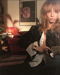 a woman sitting on top of a couch in a living room