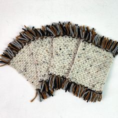 three pieces of knitted fabric with fringes on them sitting next to each other