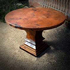 an old wooden table sitting on top of gravel