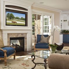 a living room filled with furniture and a flat screen tv mounted to the wall above a fireplace