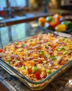 a glass casserole dish filled with lots of food on top of a counter