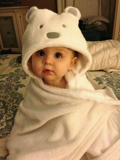 a baby wrapped in a white bear towel