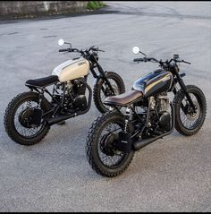 two motorcycles parked next to each other in a parking lot with no one around them