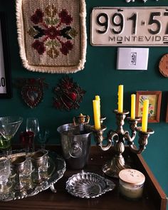 a table topped with lots of candles next to plates and glasses on top of a wooden table