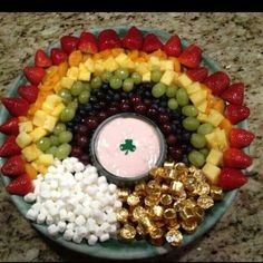 a platter filled with fruit, marshmallows, and other candy toppings