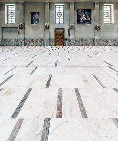 an empty room with marble floors and paintings on the walls