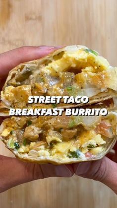 a person holding up a breakfast burrito in their hand with the words street taco breakfast burrito on it