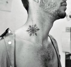 a man with a small snowflake tattoo on his neck and chest, in black and white