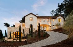 a large white house sitting on top of a lush green hillside