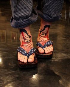 a person with tattoos on their feet wearing sandals