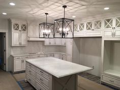 a kitchen with white cabinets and an island in the middle is being remodeled to look like it has been renovated