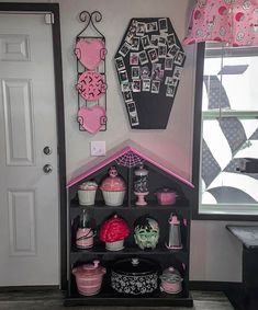 a dollhouse with pink and black decor on the walls, including cupcakes