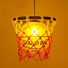 a basketball net hanging from the ceiling with an orange light in it's center