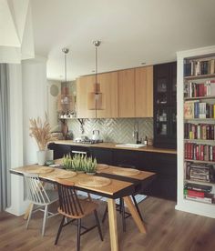 a table and chairs in a room with bookshelves