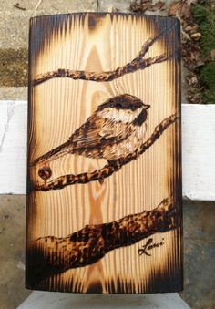 a bird sitting on top of a wooden sign