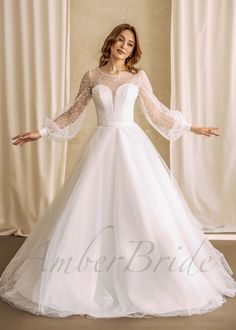 a woman in a white wedding dress posing for the camera with her arms spread out